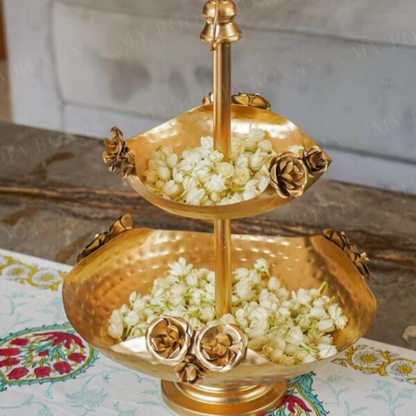 Bring a touch of elegance and charm to your home with our Gold stand  Urli . This exquisite decor piece is made of sturdy iron and features a beautifully crafted floral design in a soothing gold hue. Perfect for displaying flowers, floating candles, or potpourri, Whether you want to give your living room, bedroom, or office a sophisticated look, this piece is a must-have for any discerning homeowner. Get yours today! Material - Iron Dimensions (D*H) Dia: 12", height - 15"