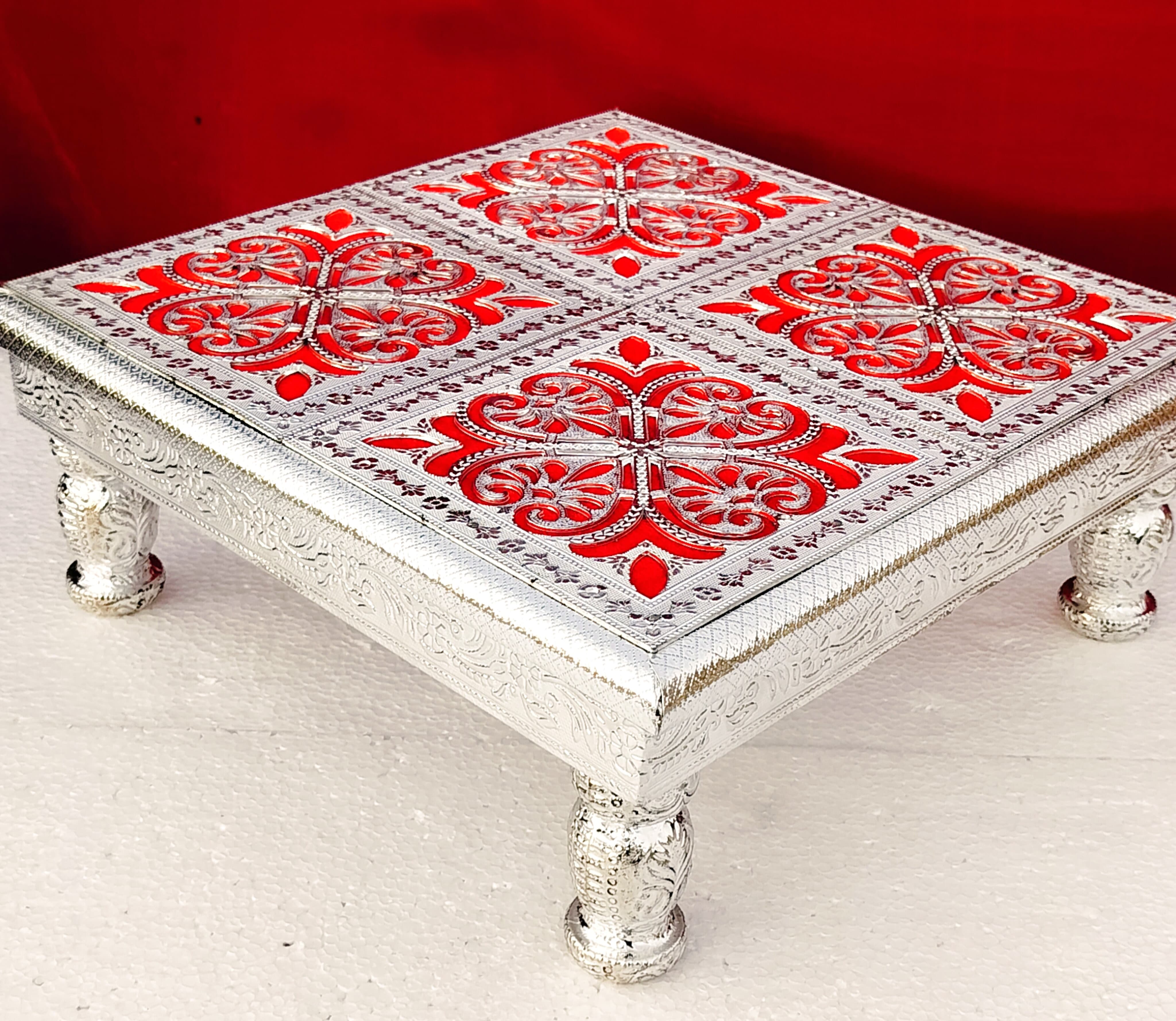 Pure German silver work on teak wood chowki with 4 Round German silver leg Description 1. Best for wedding ritual / pooja 2. Royal look with lesser cutting chowki 3. All 4 legs of chowki is detachable 4. Length and width is 15" inch 5. Height is 6" inch 6. Weight carrying capacity is up to 100 K.G.